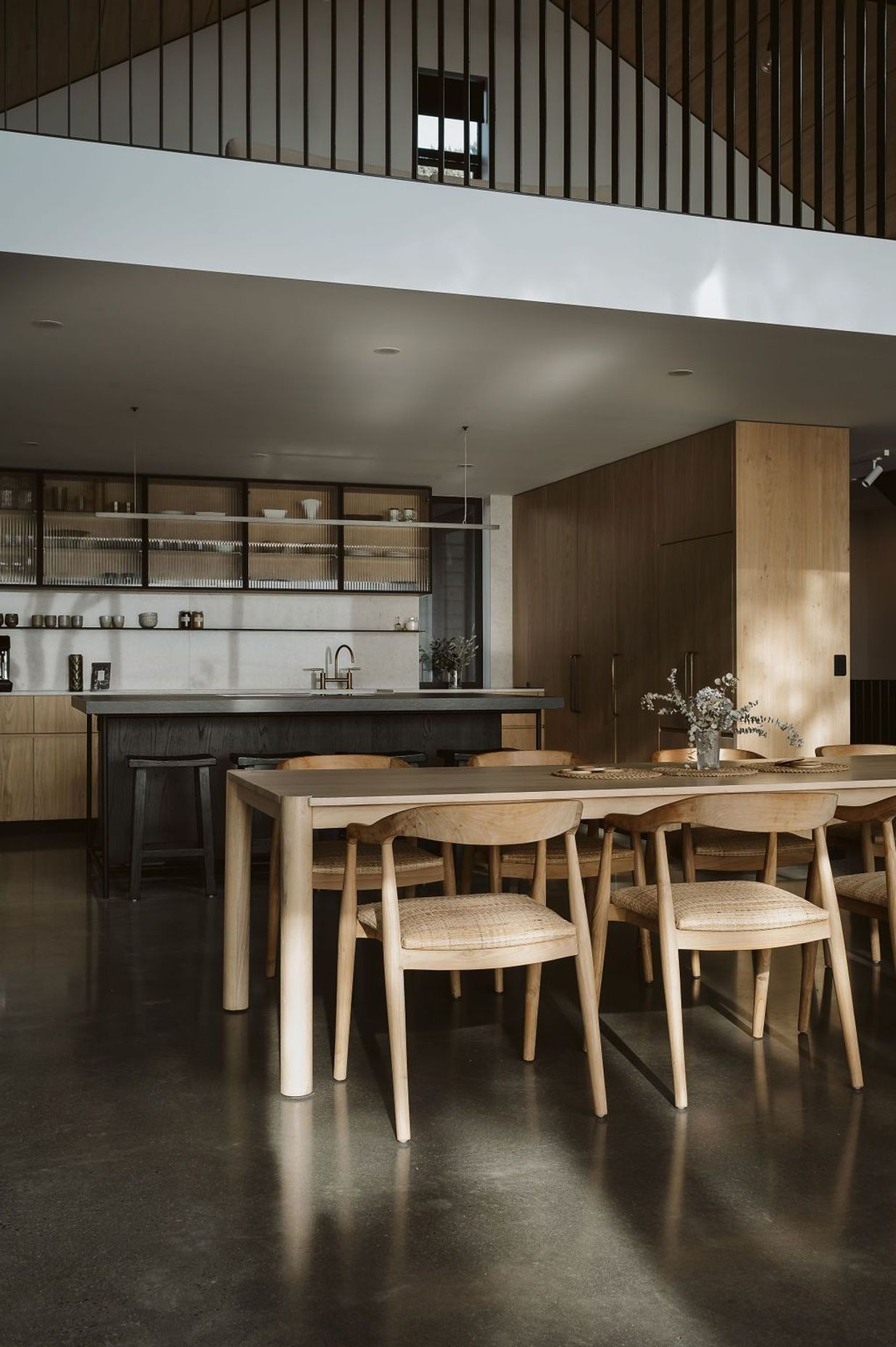The kitchen was designed, manufactured and installed by Glen John Kitchens and features hardwood cabinetry with fluted glass, a dark stained island bench and an open-plan design that connects with the dining area.