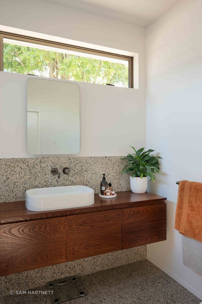 The master en suite features a mid-century materiality.
