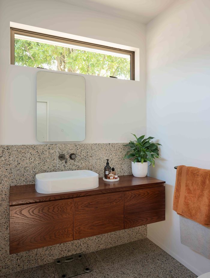 The master en suite features a mid-century materiality.