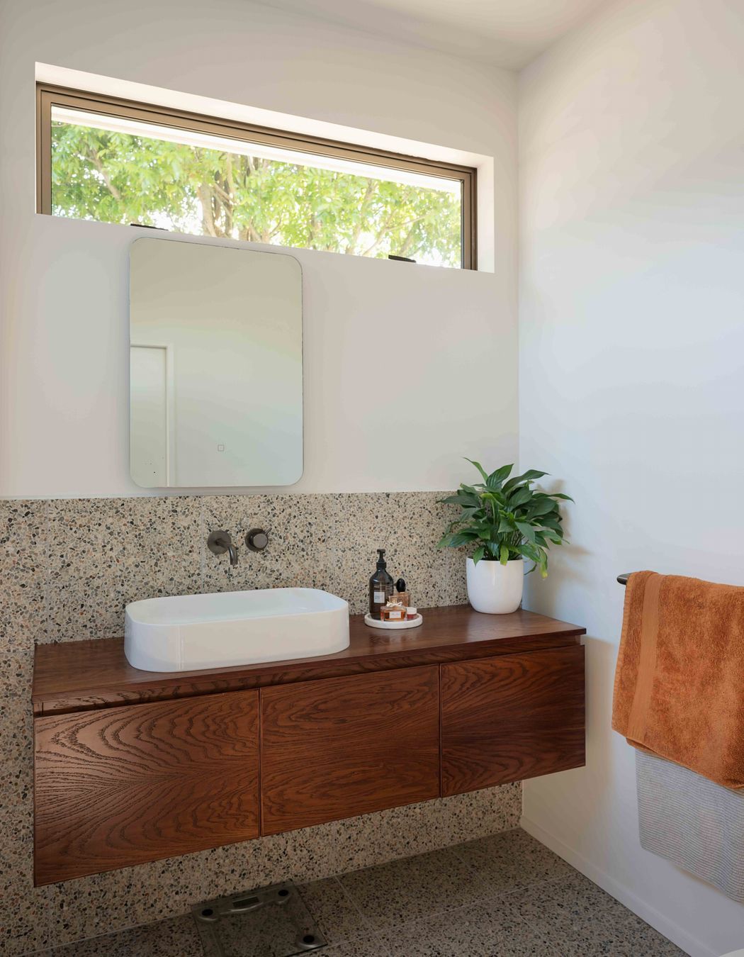 The master en suite features a mid-century materiality.