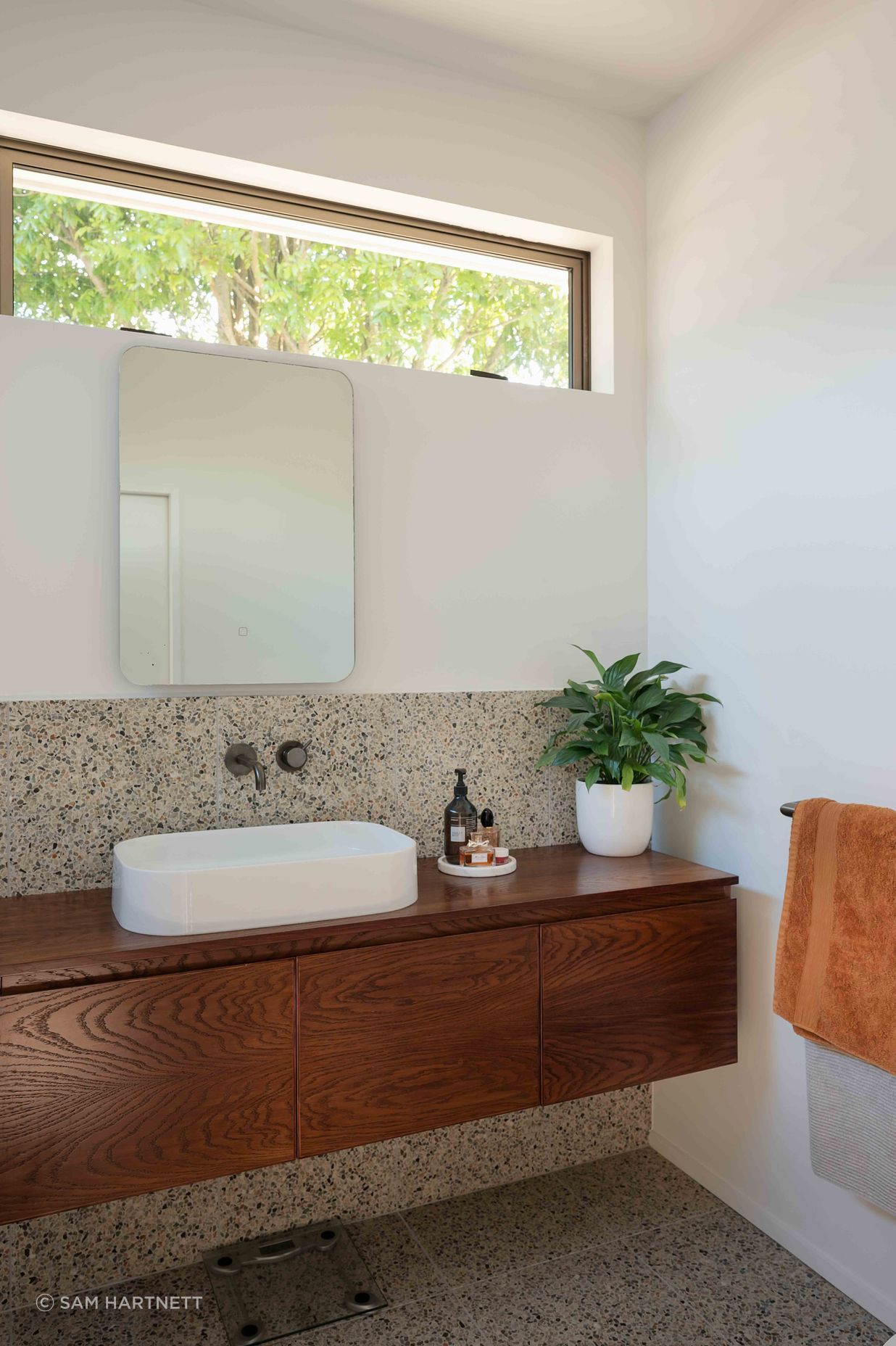 The master en suite features a mid-century materiality.