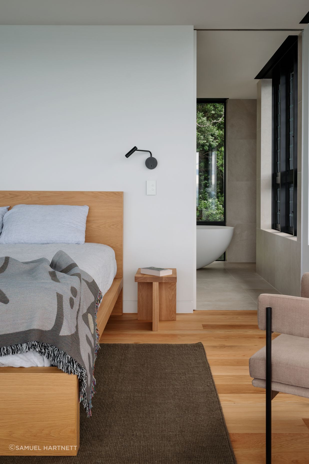 The master bedroom and bathroom. The Halford bed in oak veneer is from Simon James, and the Egg freestanding bath from Plumbline allows a bird’s eye view of the bush.