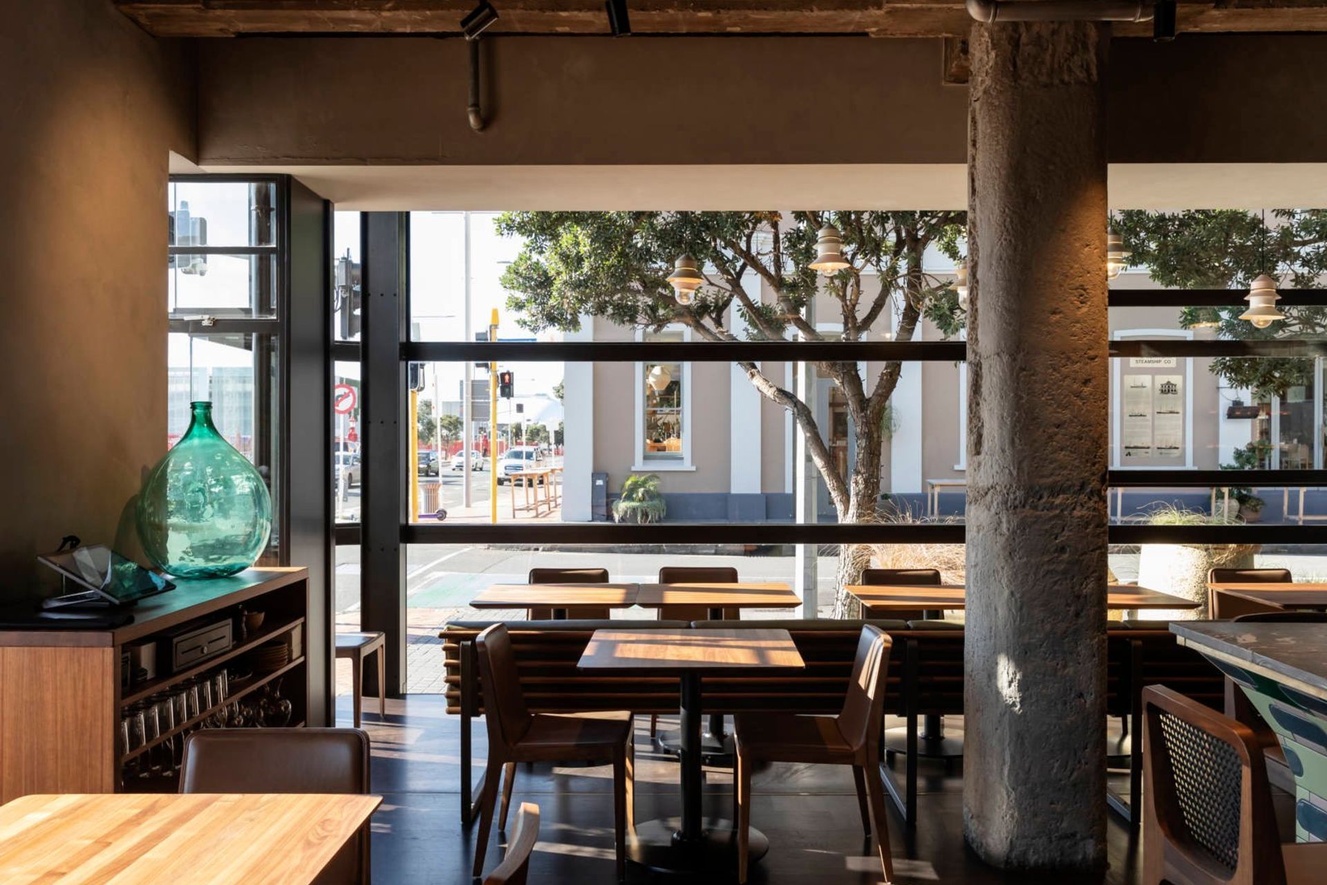 The walnut-topped tables and rich timber chairs provide a foil to the concrete elements.