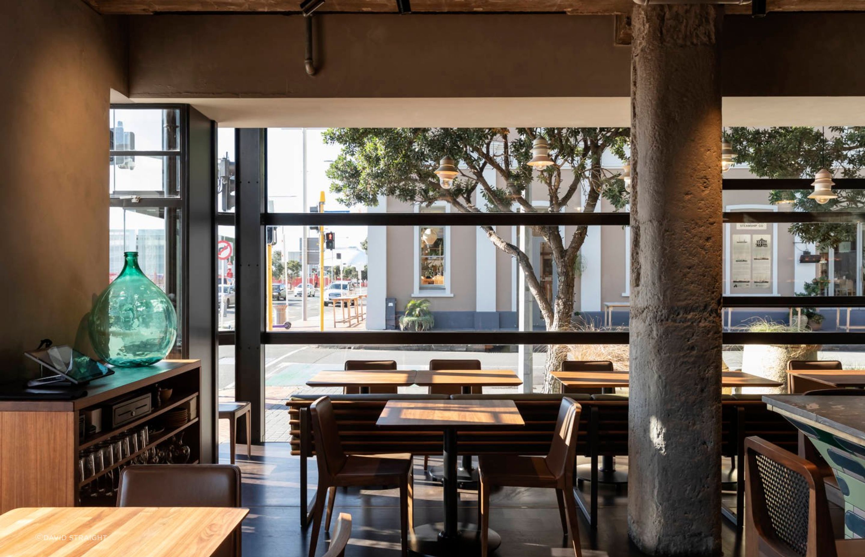 The walnut-topped tables and rich timber chairs provide a foil to the concrete elements.