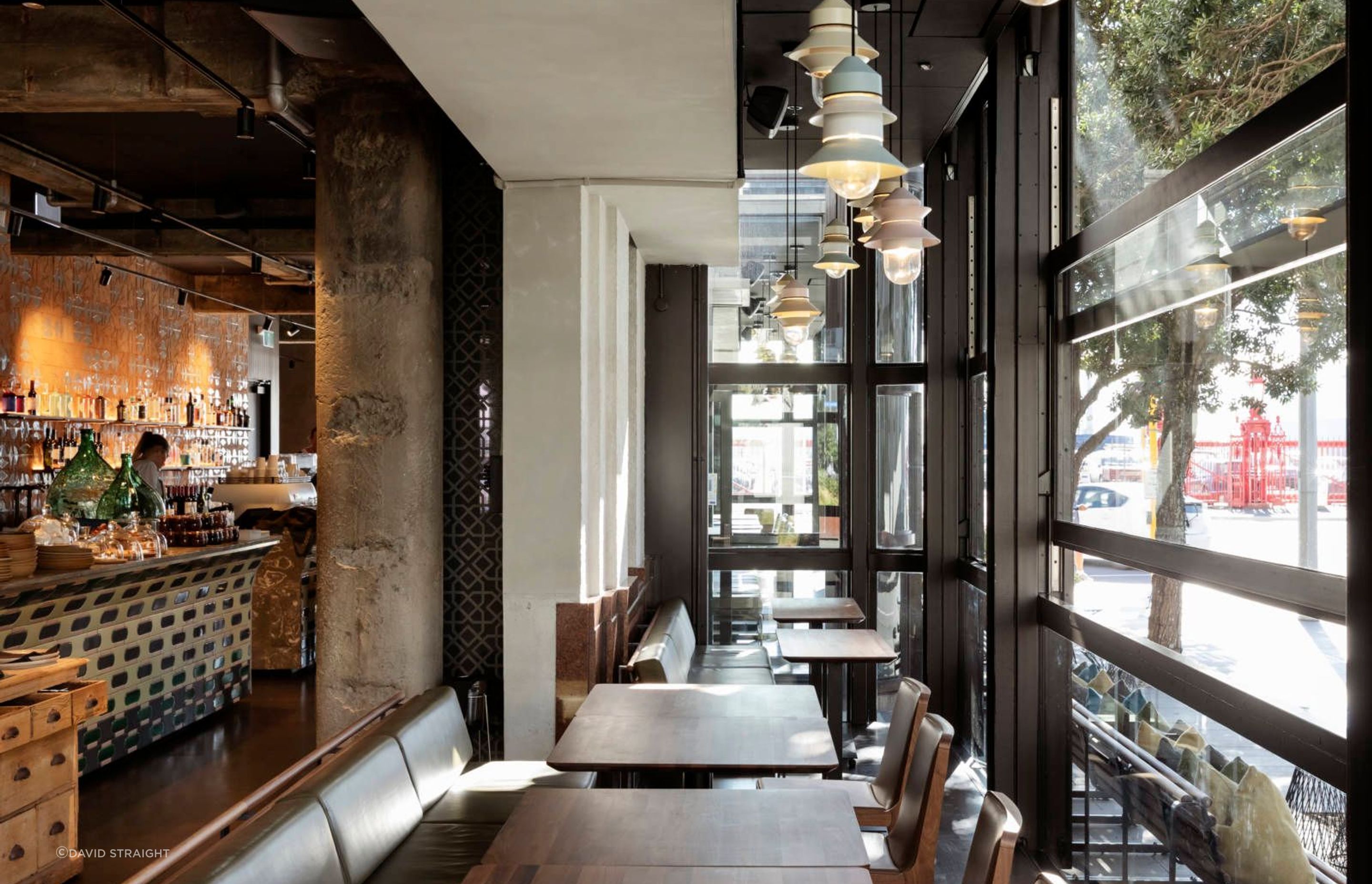 A group of small pendant lights create warmth in the dining space, without overwhelming the narrow area between the facade and the internal heritage wall.