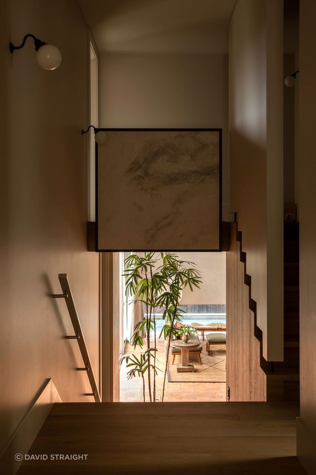 “I normally like to get a nice line of sight into a garden,” says Jack of the view from the original part of the house down into the living room. The window with the peek of pool is deliberately low to cut the view of nearby houses.