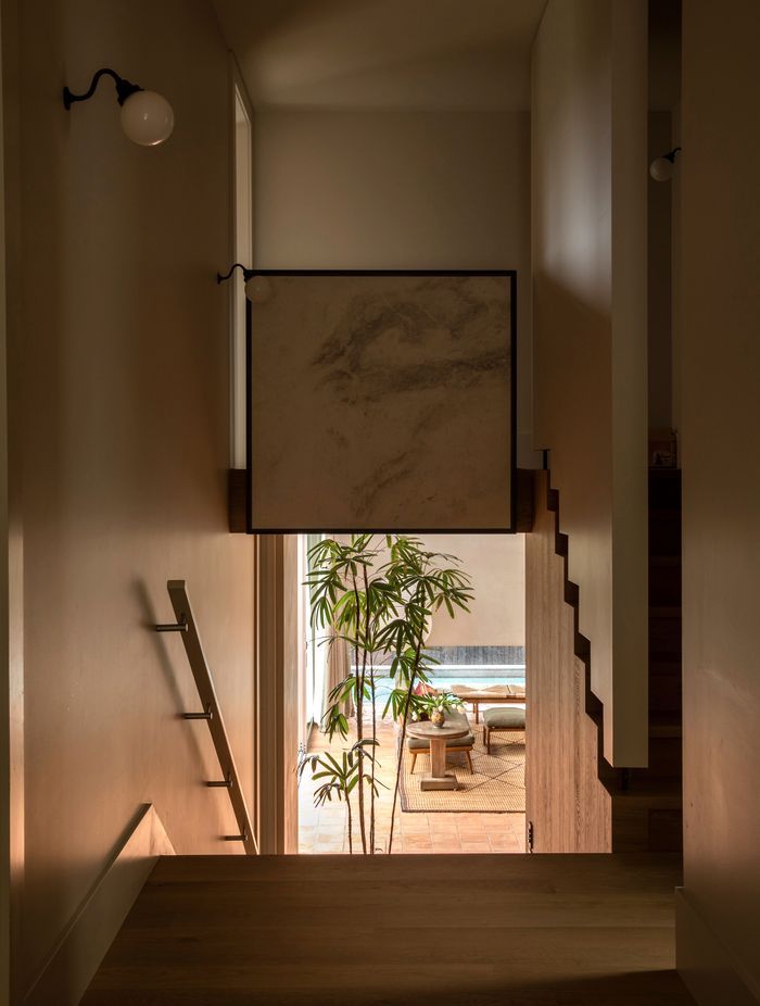 “I normally like to get a nice line of sight into a garden,” says Jack of the view from the original part of the house down into the living room. The window with the peek of pool is deliberately low to cut the view of nearby houses.