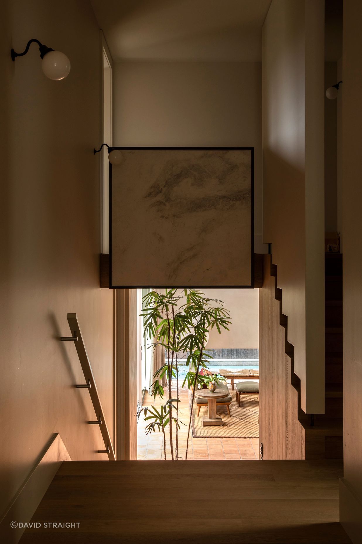 “I normally like to get a nice line of sight into a garden,” says Jack of the view from the original part of the house down into the living room. The window with the peek of pool is deliberately low to cut the view of nearby houses.