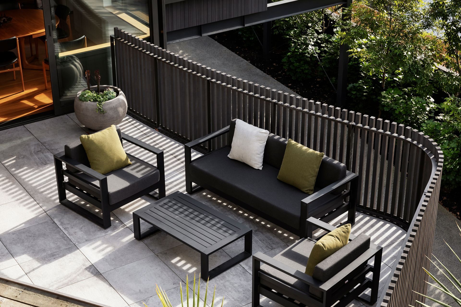 The morning terrace viewed from the elevated vegetable garden. The cladding and balustrades are eco-conscious Abodo wood. “You have a nice sense of containment when you're on the terrace, but with the ability to see through the gaps,” says Hamish.