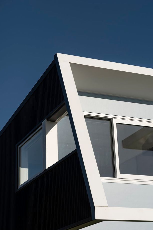 On the west, street-facing elevation, the second level protrudes over the downstairs with an elevated deck and pergola, creating shade and protection from the prevailing wind on both levels.