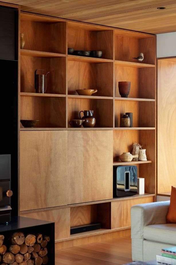 Timber bookshelves in the sitting area with sliding panels concealing a TV. “I was keen to use natural finishes and avoid paint wherever possible,” says Hamish.