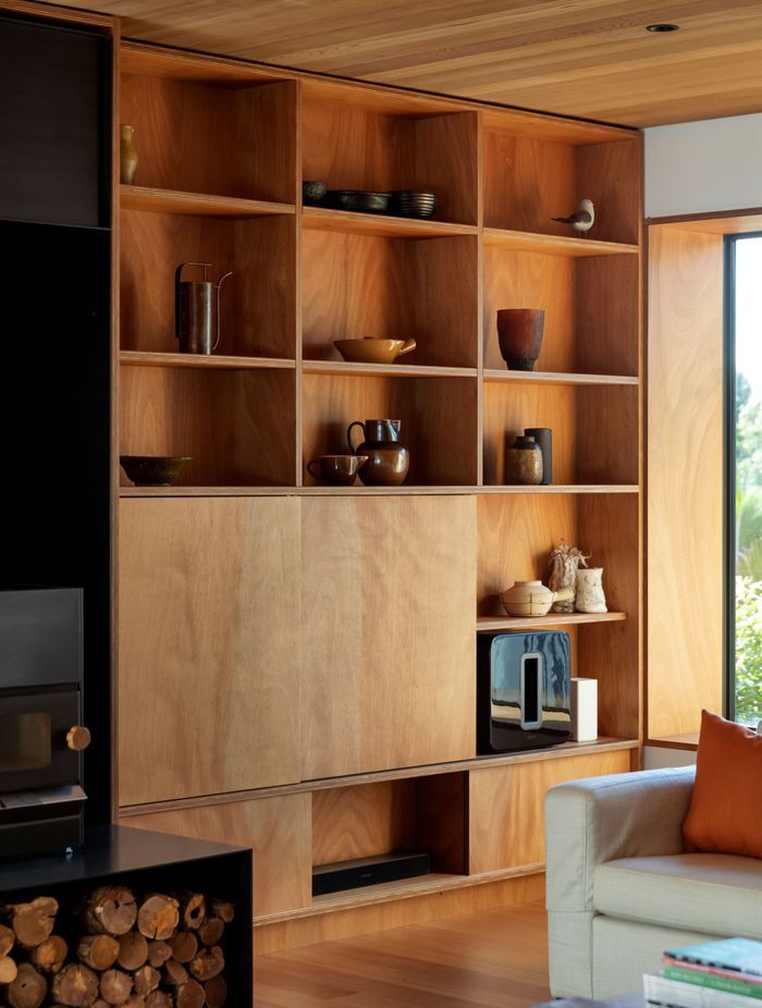 Timber bookshelves in the sitting area with sliding panels concealing a TV. “I was keen to use natural finishes and avoid paint wherever possible,” says Hamish.