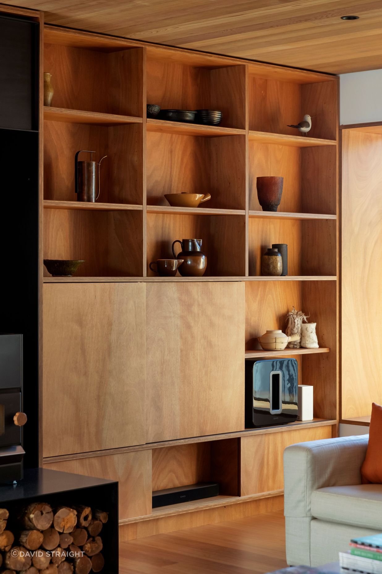 Timber bookshelves in the sitting area with sliding panels concealing a TV. “I was keen to use natural finishes and avoid paint wherever possible,” says Hamish.