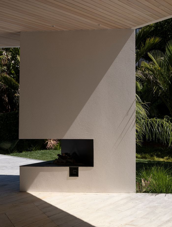 The irregular triangle design of the outdoor fireplace showcases the beauty of the crisp plaster finish.