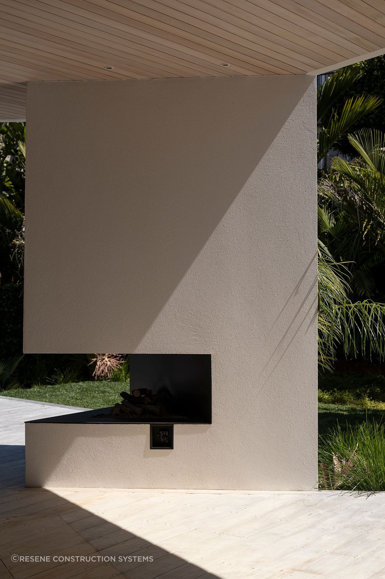 The irregular triangle design of the outdoor fireplace showcases the beauty of the crisp plaster finish.