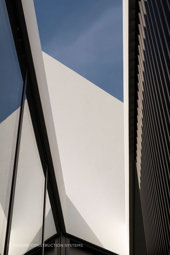 The shadows from the cedar fins are beautifully reflected by the glass and as shadows on the plaster surfaces, creating a constant play of light and shadow.