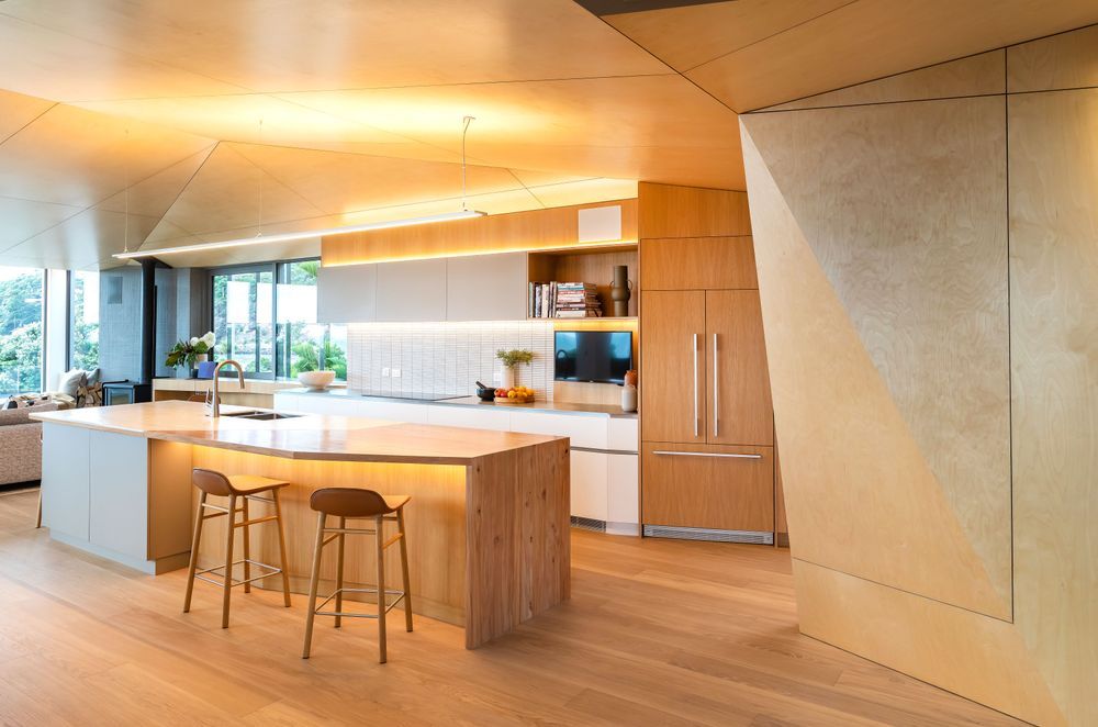 Driftwood Home's kitchen is open and bright, with angled walls to ensure the ocean view can be enjoyed from the kitchen island.