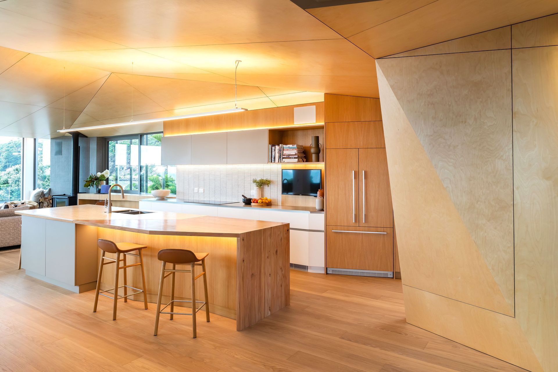 Driftwood Home's kitchen is open and bright, with angled walls to ensure the ocean view can be enjoyed from the kitchen island.