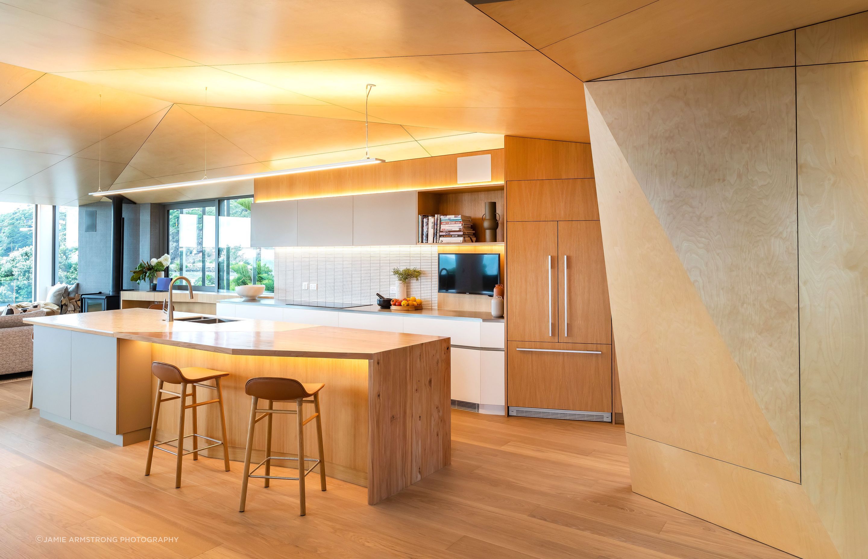 Driftwood Home's kitchen is open and bright, with angled walls to ensure the ocean view can be enjoyed from the kitchen island.