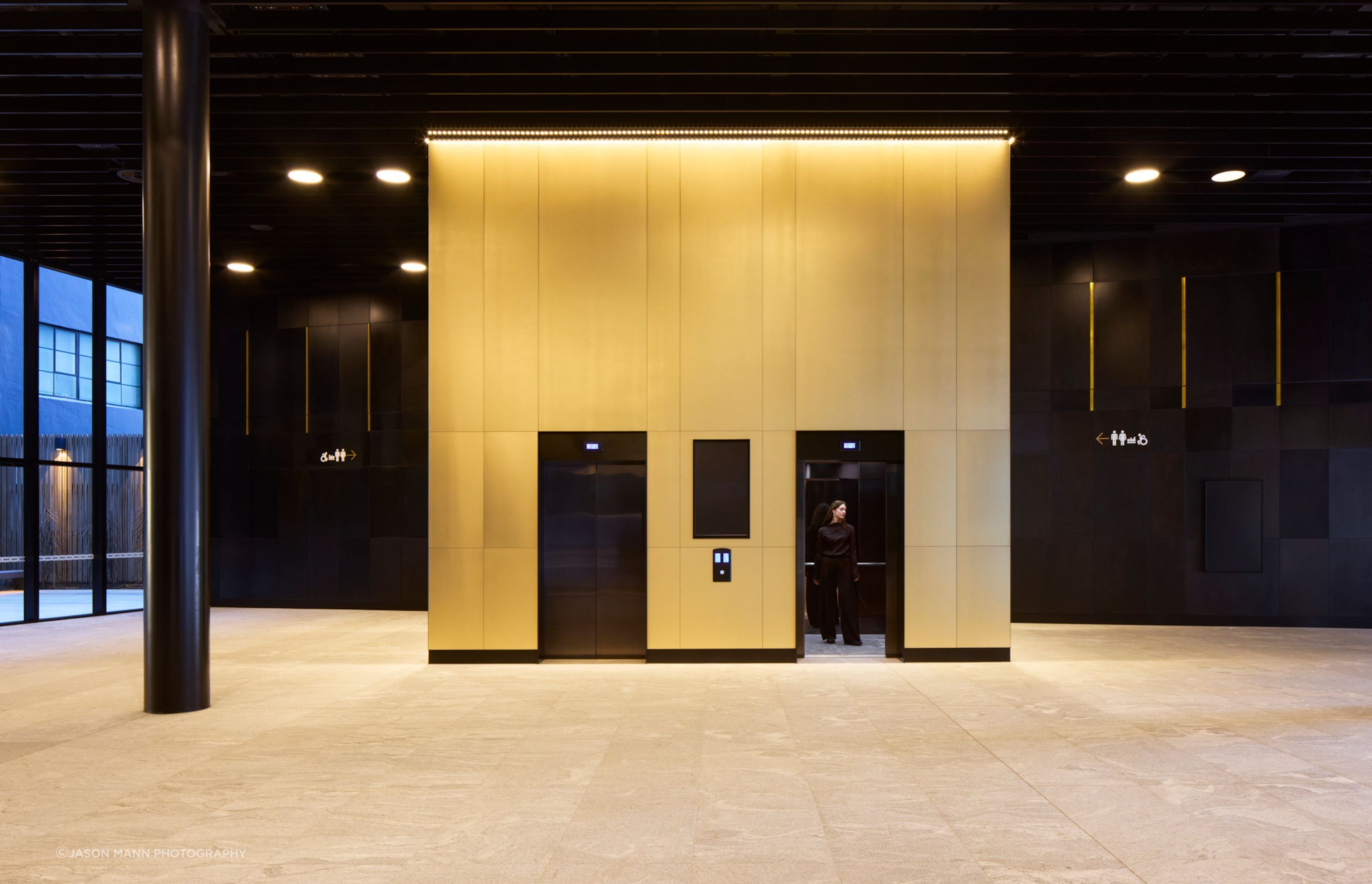 The building's public elevators, beautifully contrasted with the dark hardboard walls.