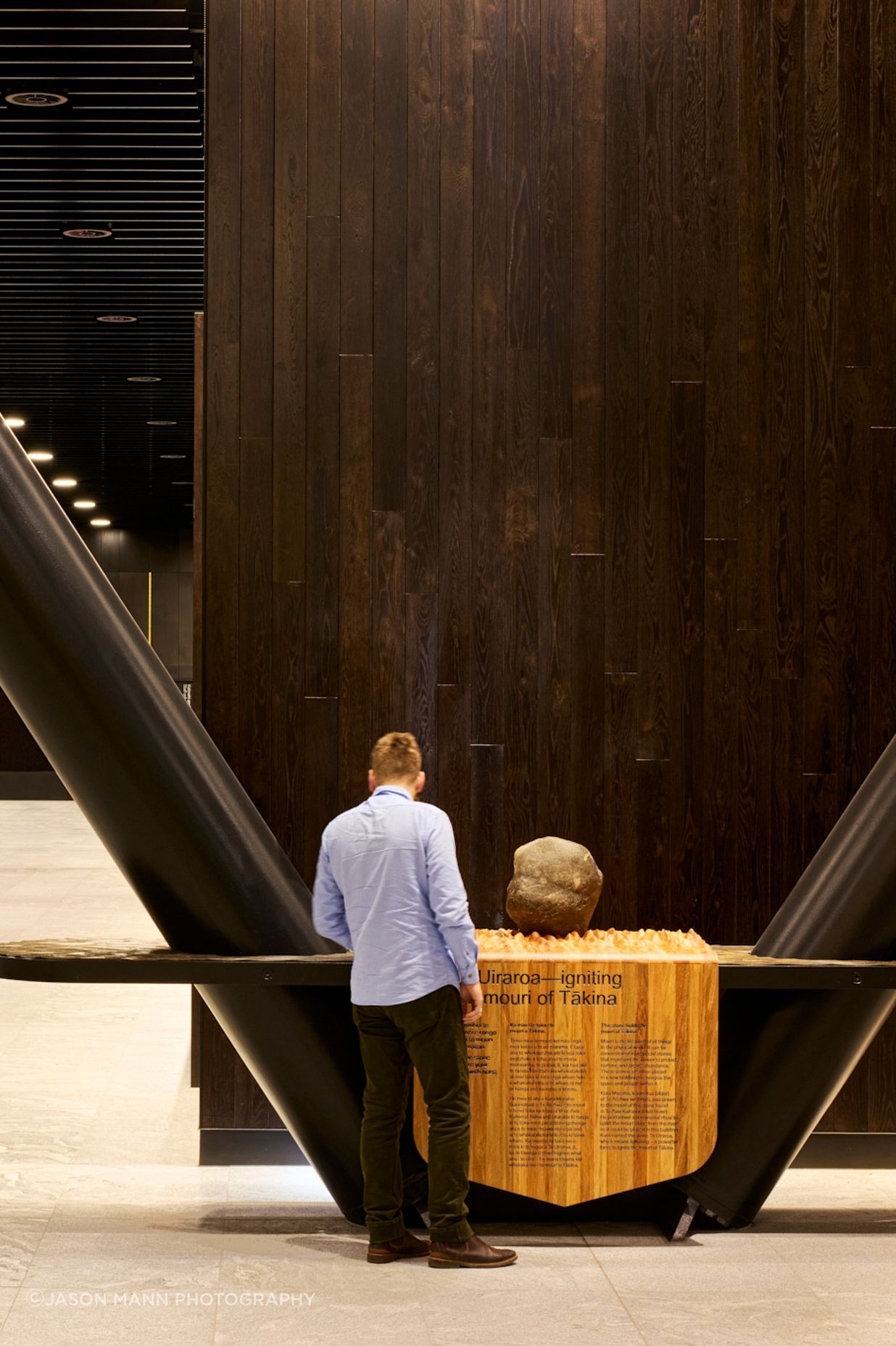 The mouri stone, sitting on hand-carved timber that's mounted for display.