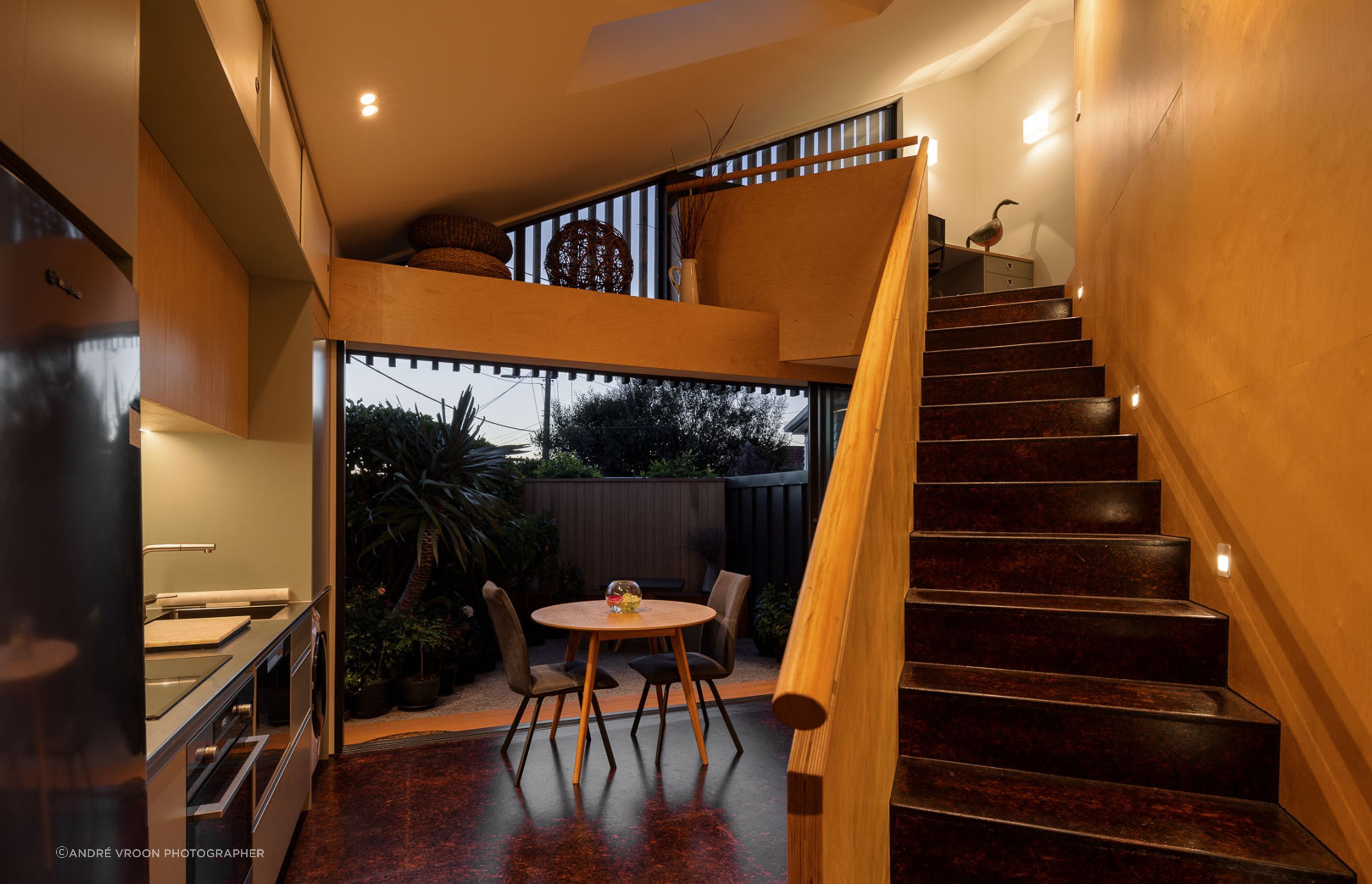 The staircase forms the spine of the home, with triangular spaces fanning out from it.