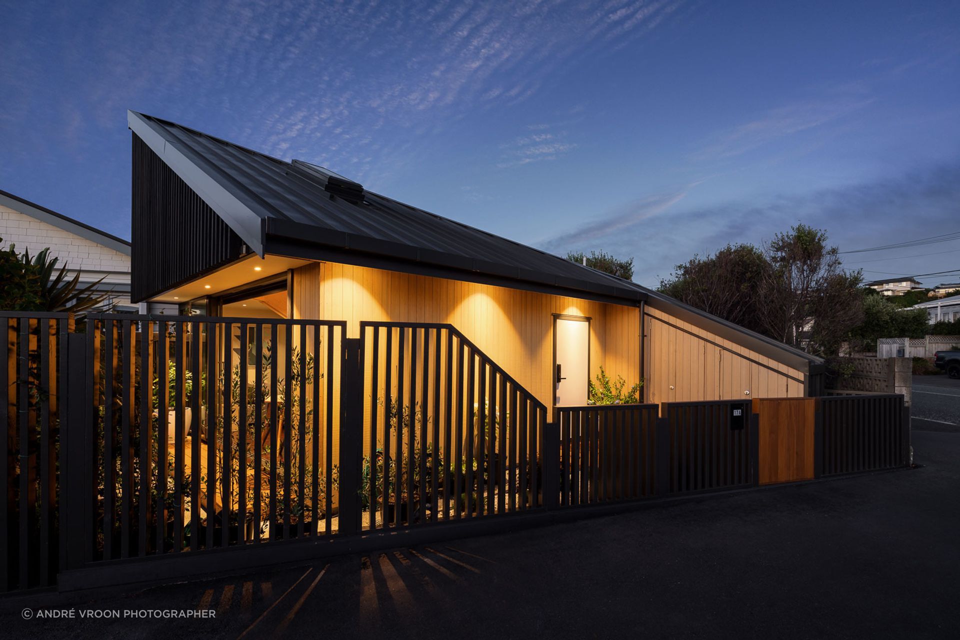 The warmth of the Abodo cladding contrasts sharply against the steel tray profile roof, and stained timber screens.