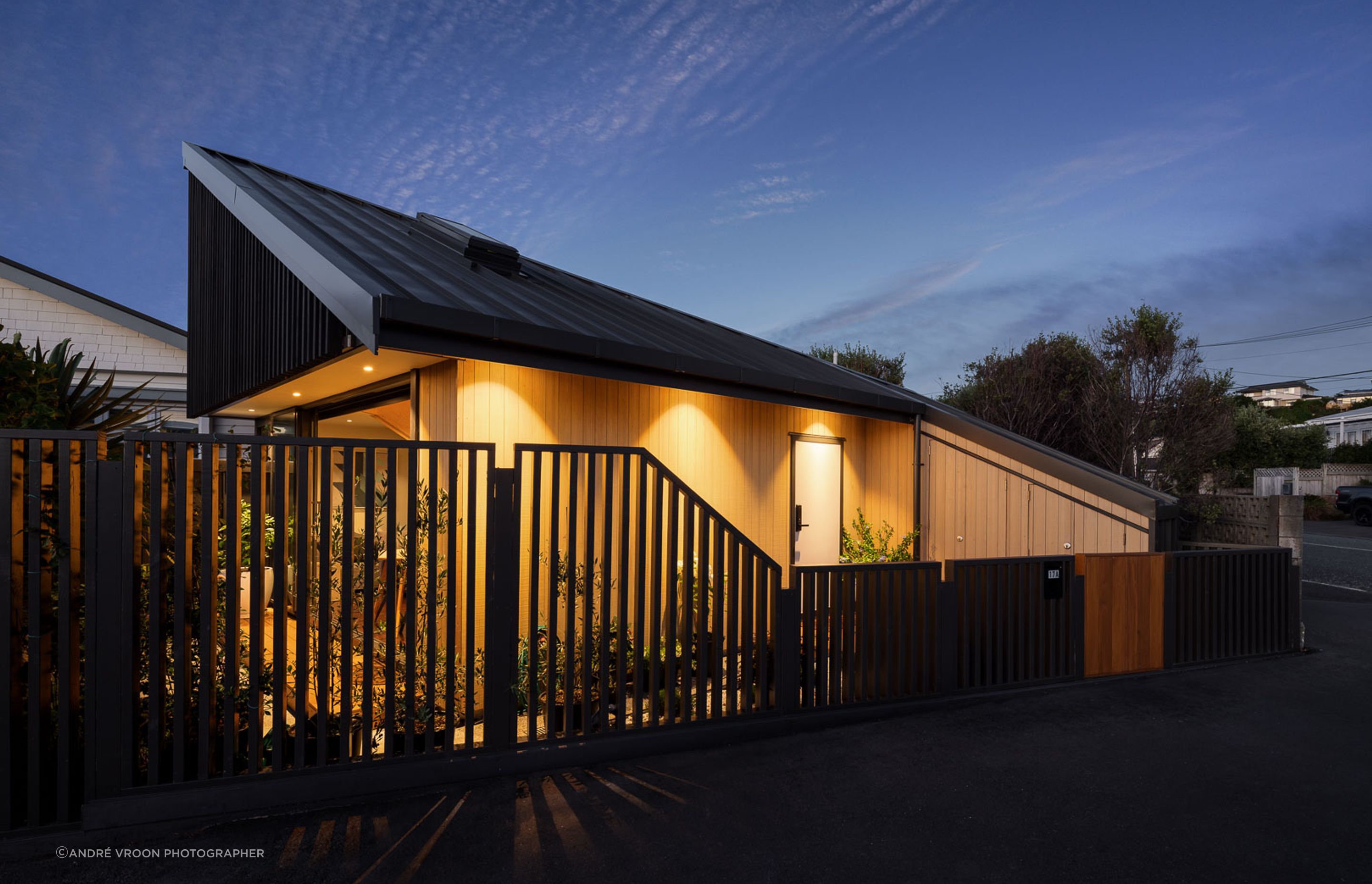 The warmth of the Abodo cladding contrasts sharply against the steel tray profile roof, and stained timber screens.