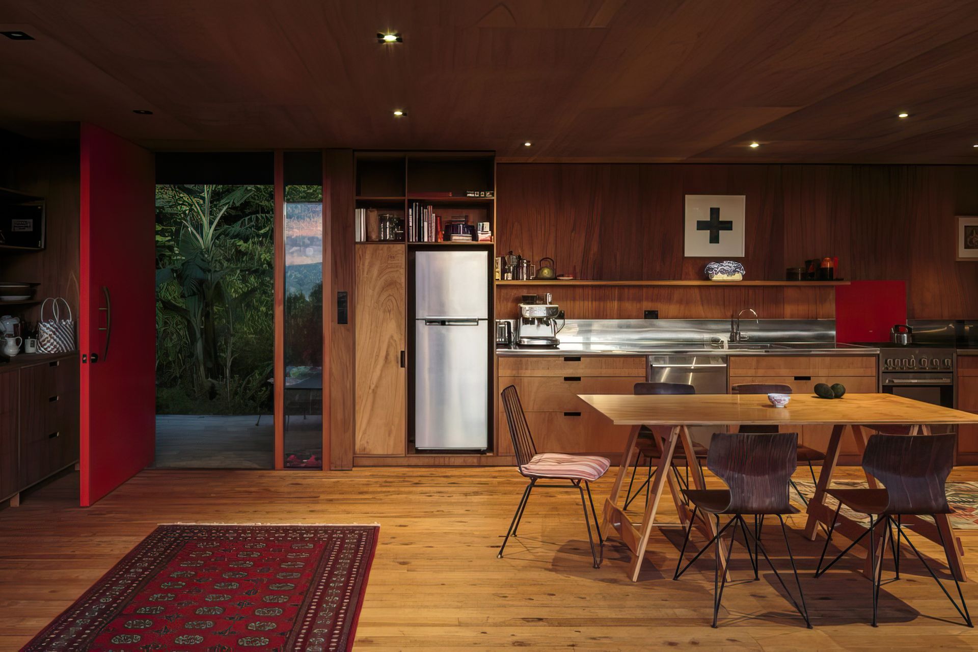 The open-plan living room is anchored only by the kitchen bench at the back and small log fire at one end.