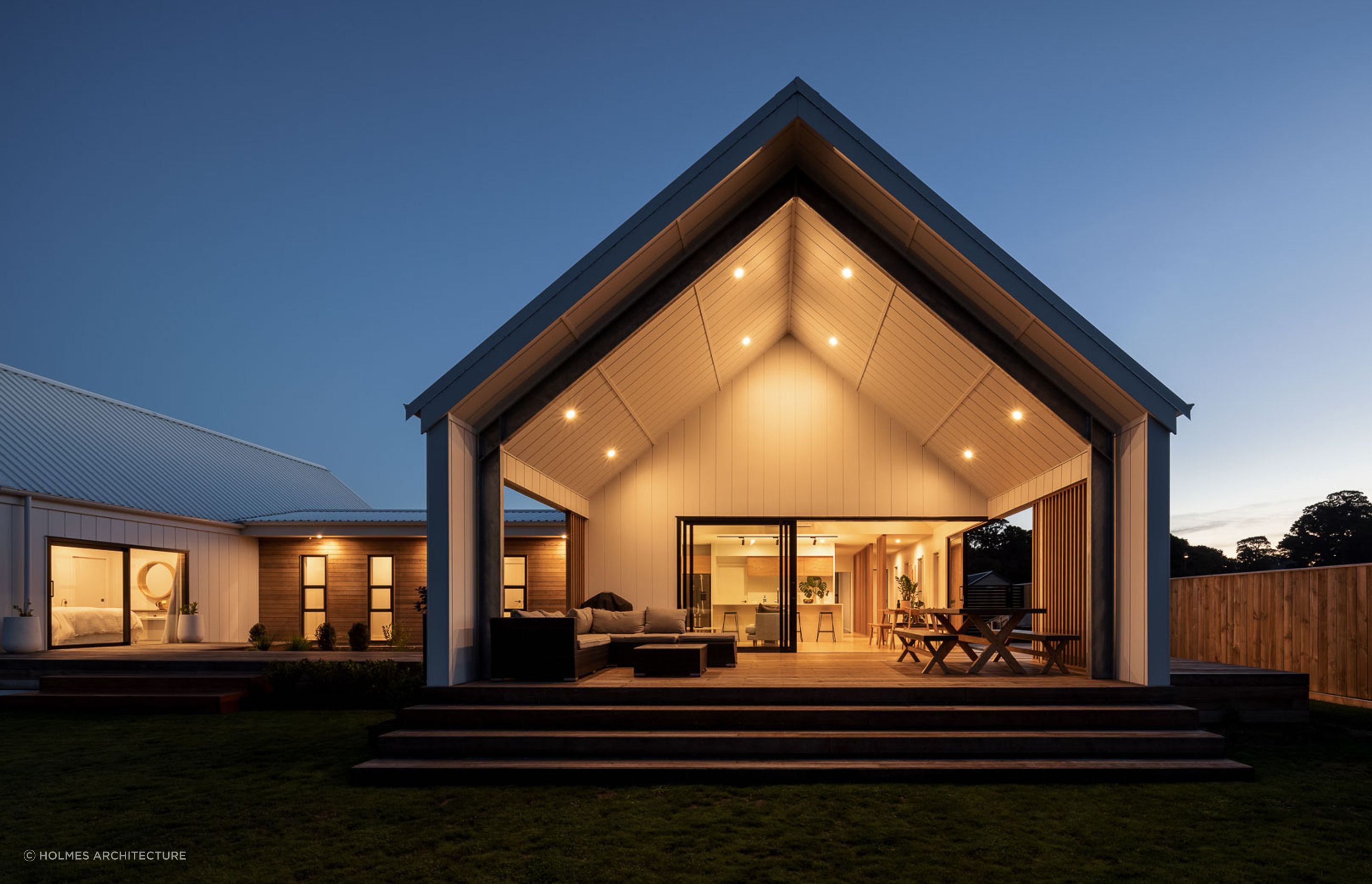 The magnificence of the gabled pavilions and contrasting use of weatherboards can still be appreciated at dusk with its excellent outdoor lighting design. | Photography: André Vroon Photographer