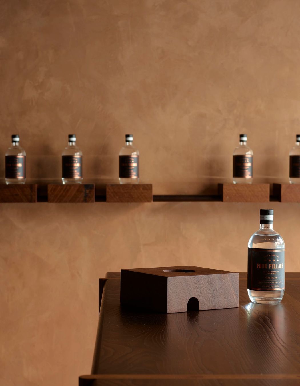 Grooved solid timber blocks with a range of gin bottles can be removed from their metal rail base; instantly converting the store to a cellar door.