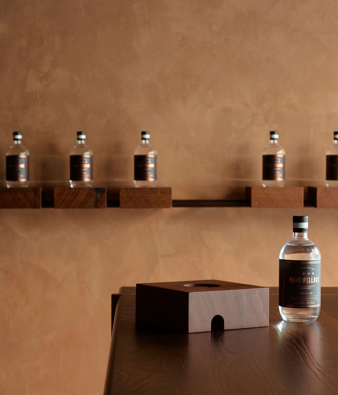 Grooved solid timber blocks with a range of gin bottles can be removed from their metal rail base; instantly converting the store to a cellar door.