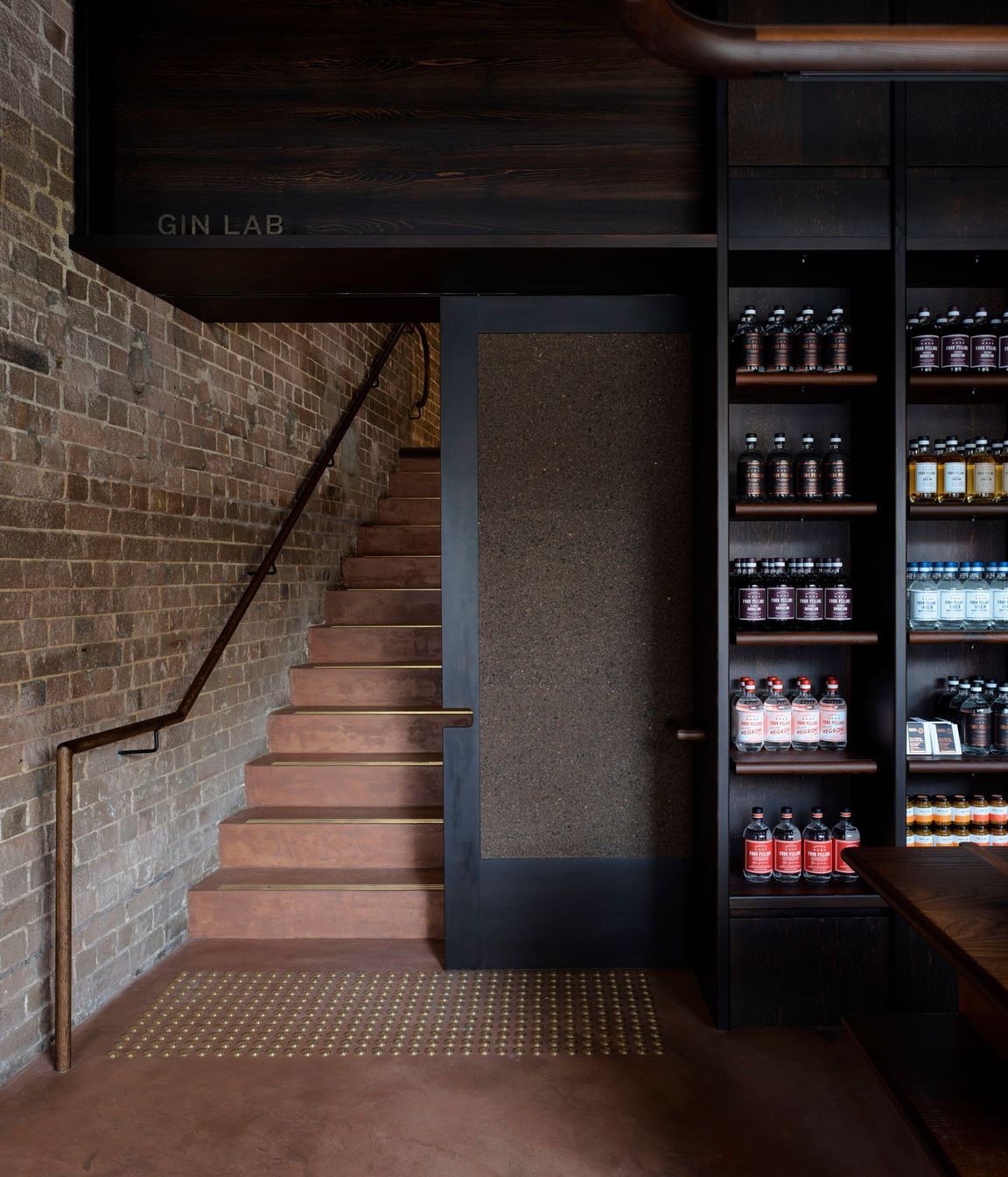 Micro-cement rendered walls and floors with a Pandomo finish add a rustic vibe with a nod to the Four Pillars’ copper-toned logo.