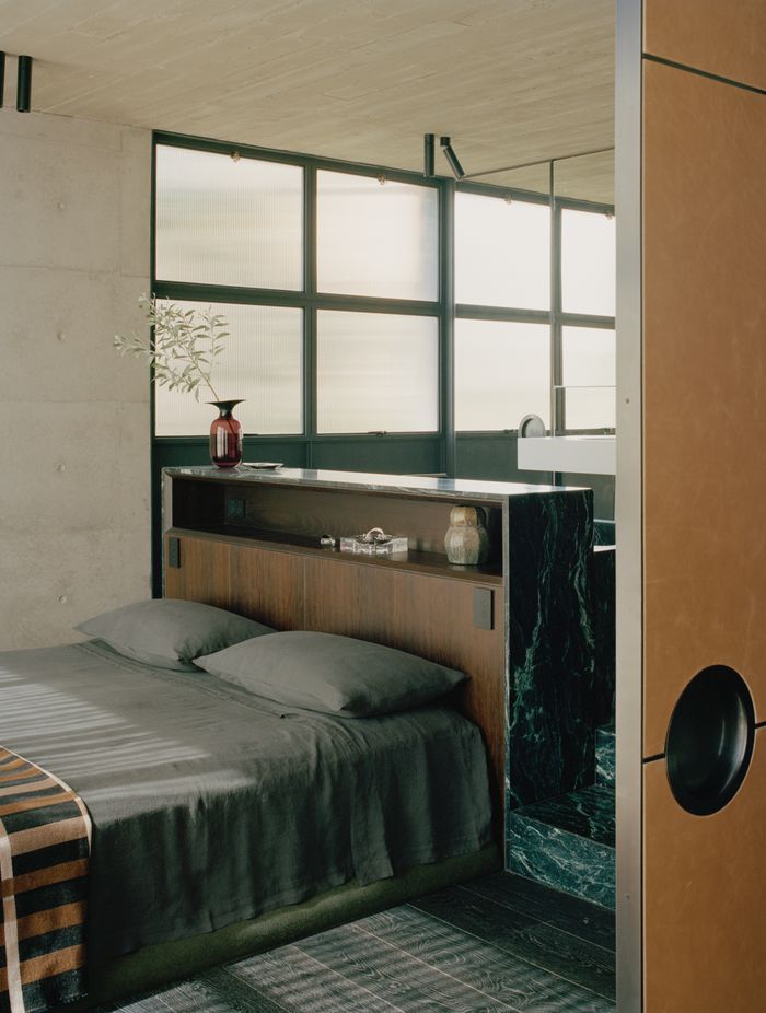 In the master bedroom, the bedhead is formed by the back of the marble bath.
