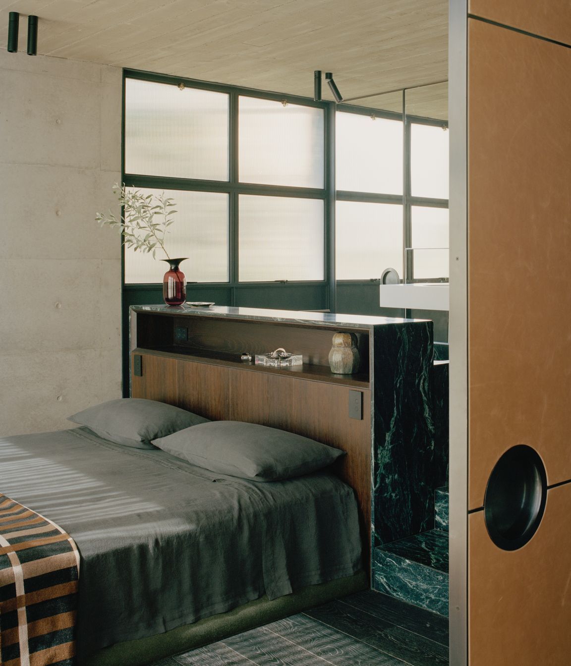In the master bedroom, the bedhead is formed by the back of the marble bath.