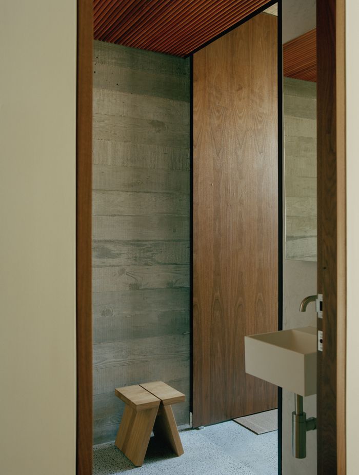The textured timber board markings on the concrete walls integrate perfectly with the timber slatted ceilings.