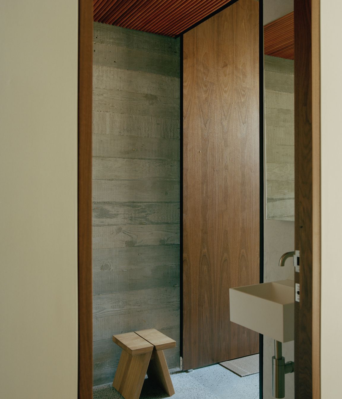 The textured timber board markings on the concrete walls integrate perfectly with the timber slatted ceilings.