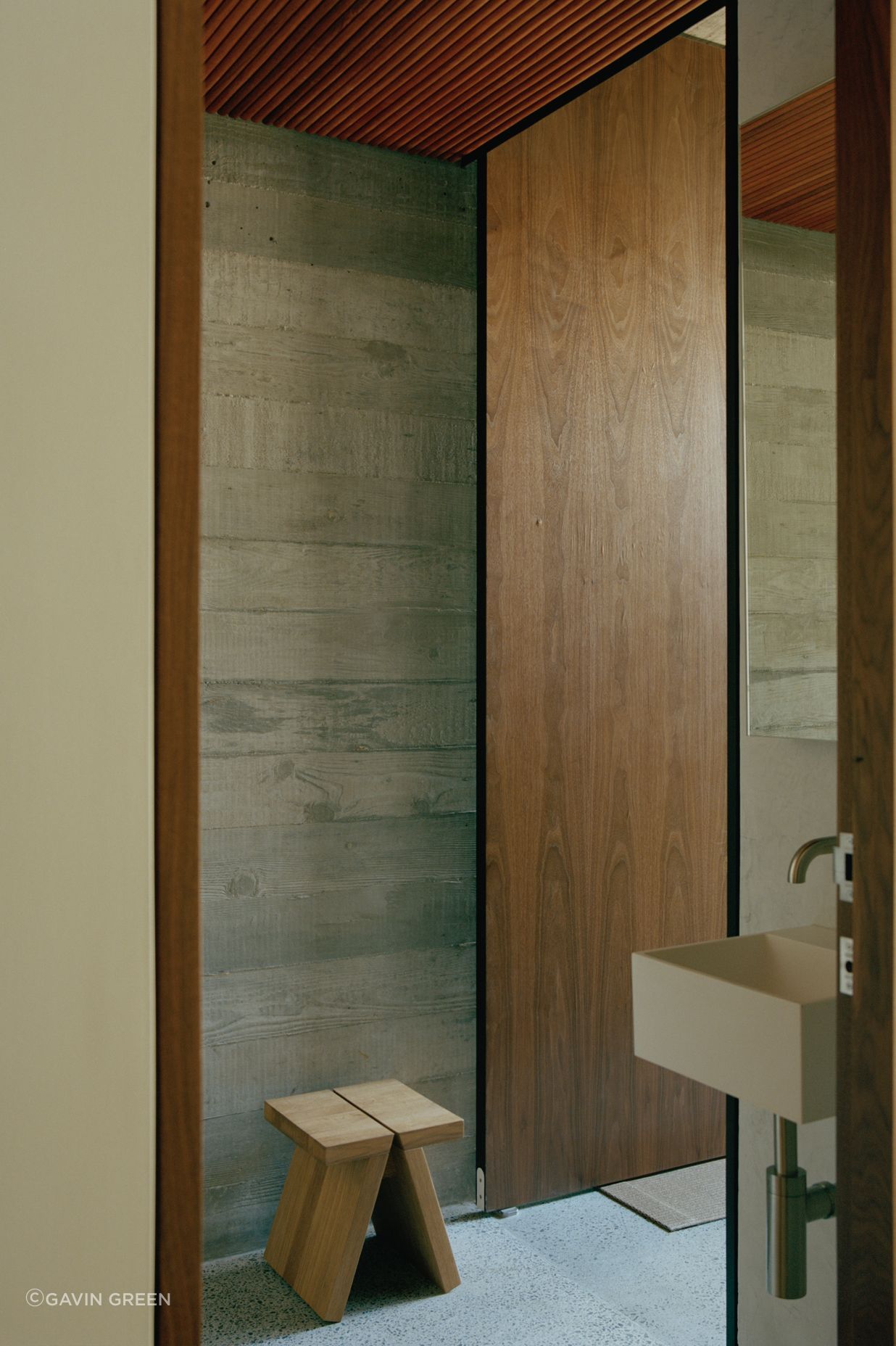 The textured timber board markings on the concrete walls integrate perfectly with the timber slatted ceilings.
