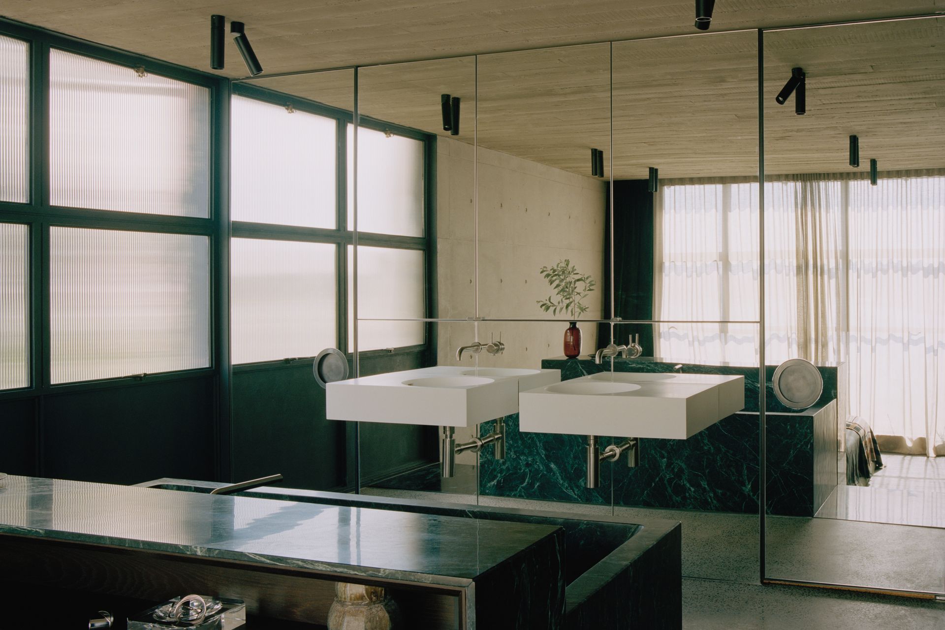 The master en suite features dramatic black marble and a mirrored wall.