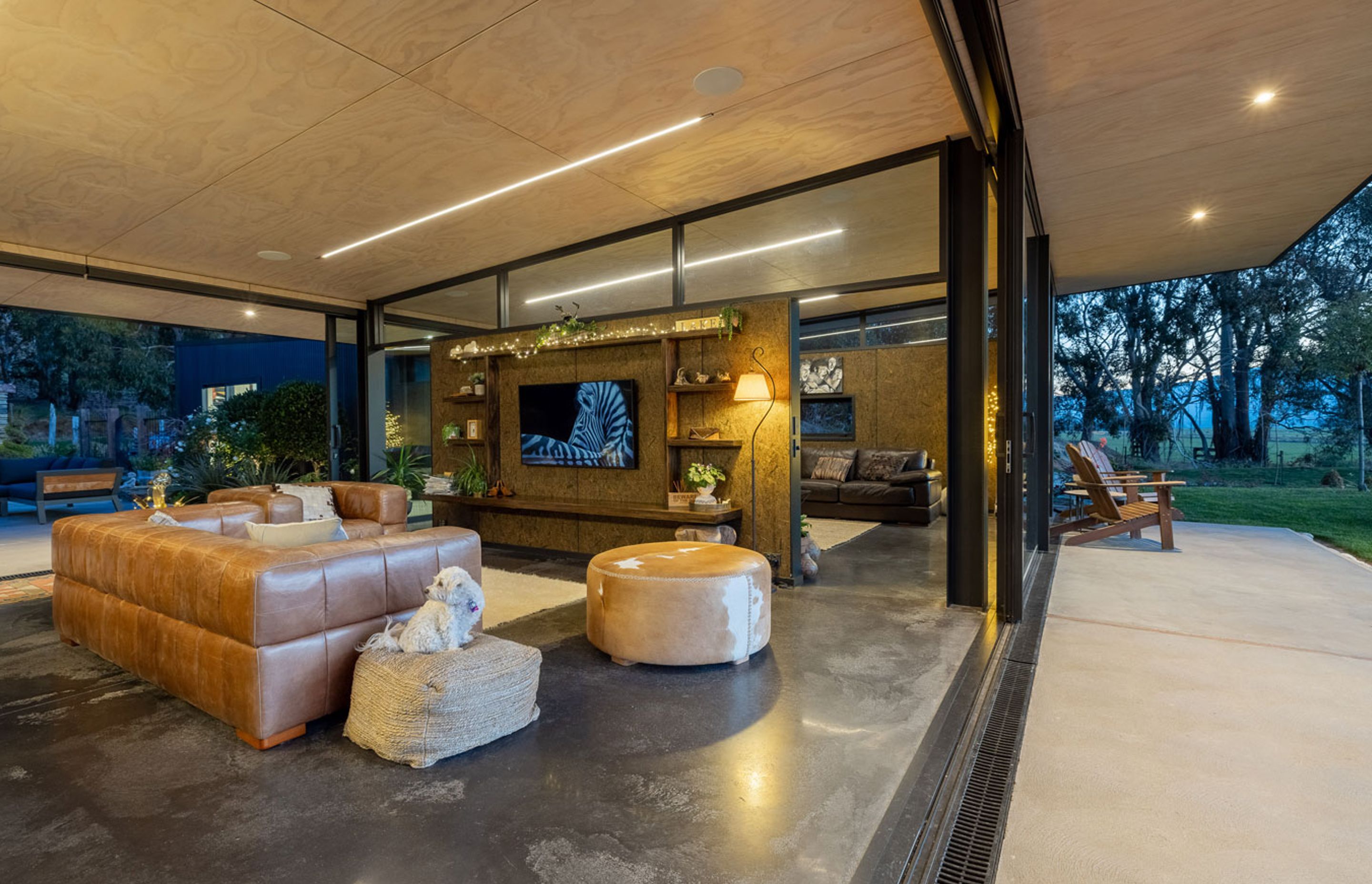 The dividing wall creates two living spaces while retaining the open-plan flow. Strip lighting in the ceiling is a departure from typical downlighting, says Gary. It complements the lines of the ceiling during the day and leads the eye outside.