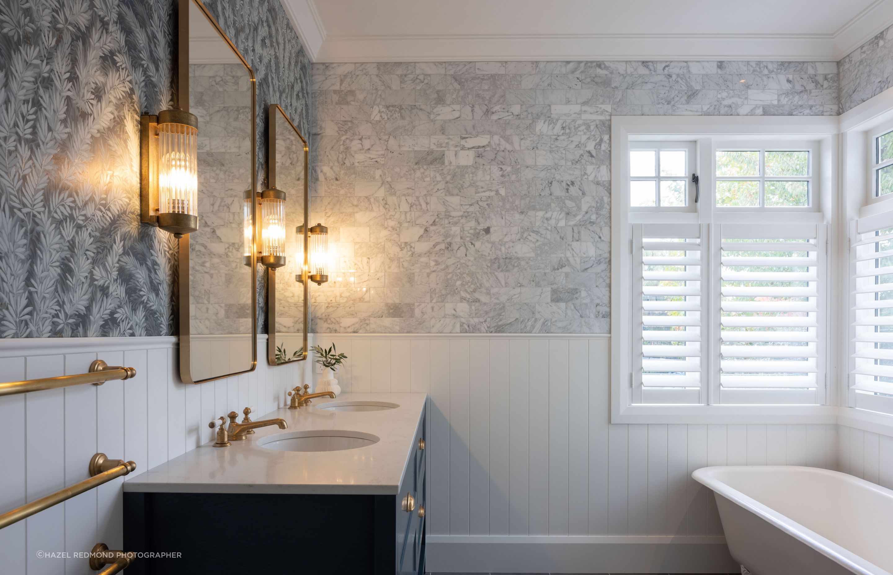 The hotel-like feel continues in the bathrooms, with elegant sconces, a clawfoot tub, and gold fixtures.