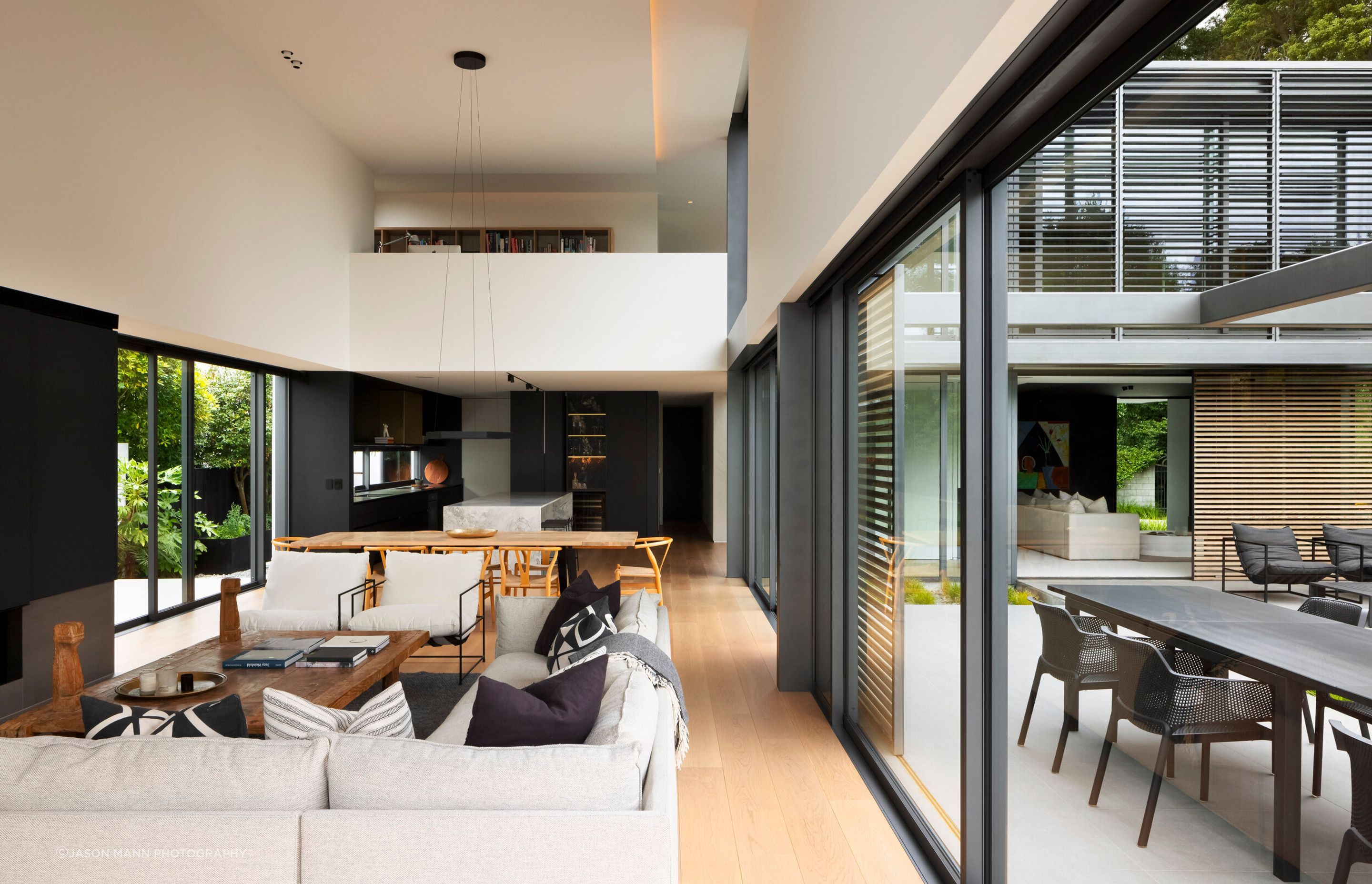 Upstairs, a mezzanine level with a study overlooks the double-height living area.