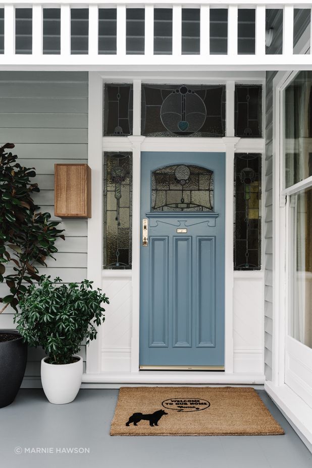 The original front door with stained glass has been refreshed with a coat of pale French blue paint.