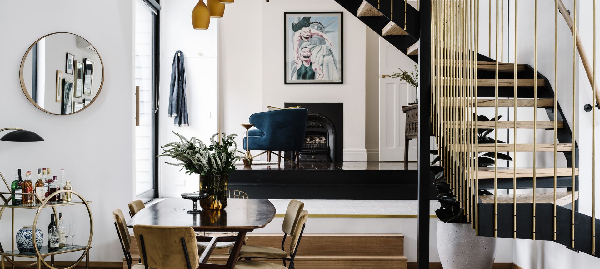 A large glass pivot door serves as a side entrance, welcoming guests directly where the original home meets the new extension. A seating area drops down to the lounge and dining. Image credit: Marnie Hawson