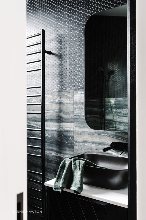 The master ensuite is a contrast to the main bathroom with its dark, masculine colour palette.