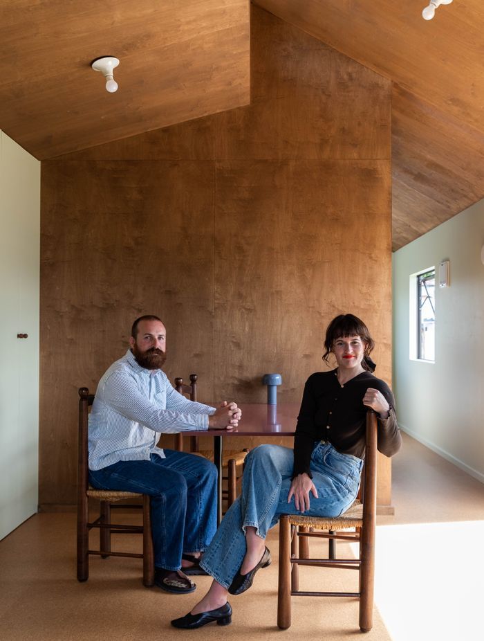 Oliver Starr (left) and Sammy Scapens (right) sit at the table in a completed Homewerk cabin.