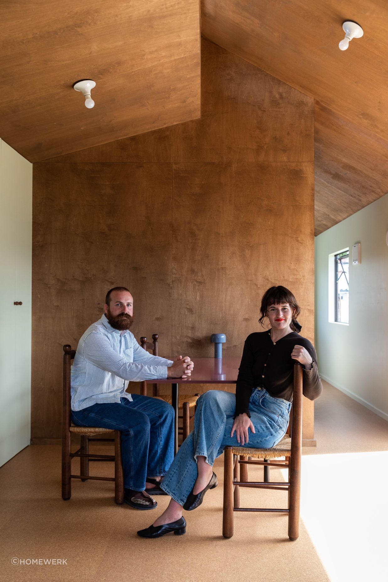 Oliver Starr (left) and Sammy Scapens (right) sit at the table in a completed Homewerk cabin.