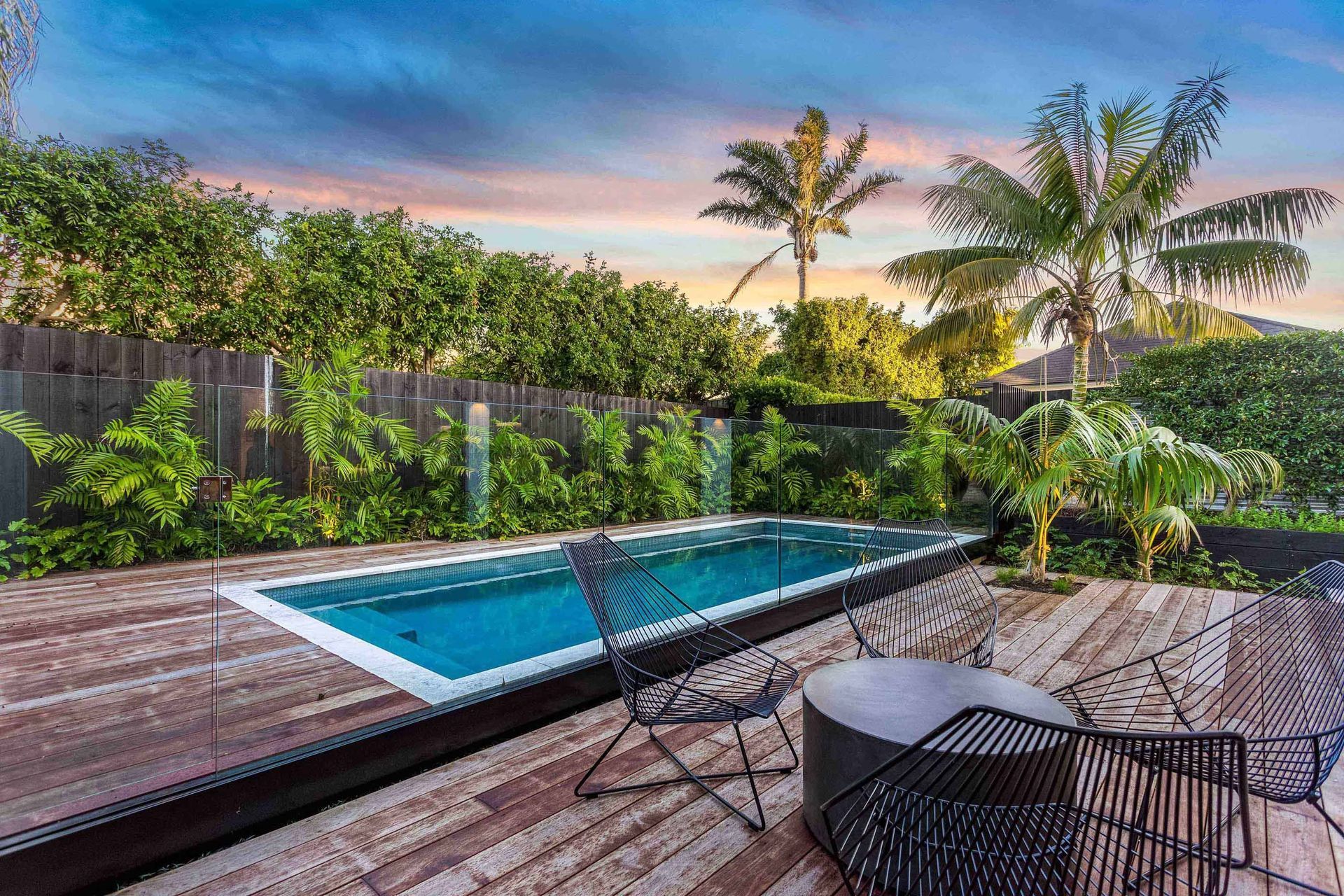 The pool area is enclosed by Kwila decking and generous semi-tropical planting to soften the edges.
