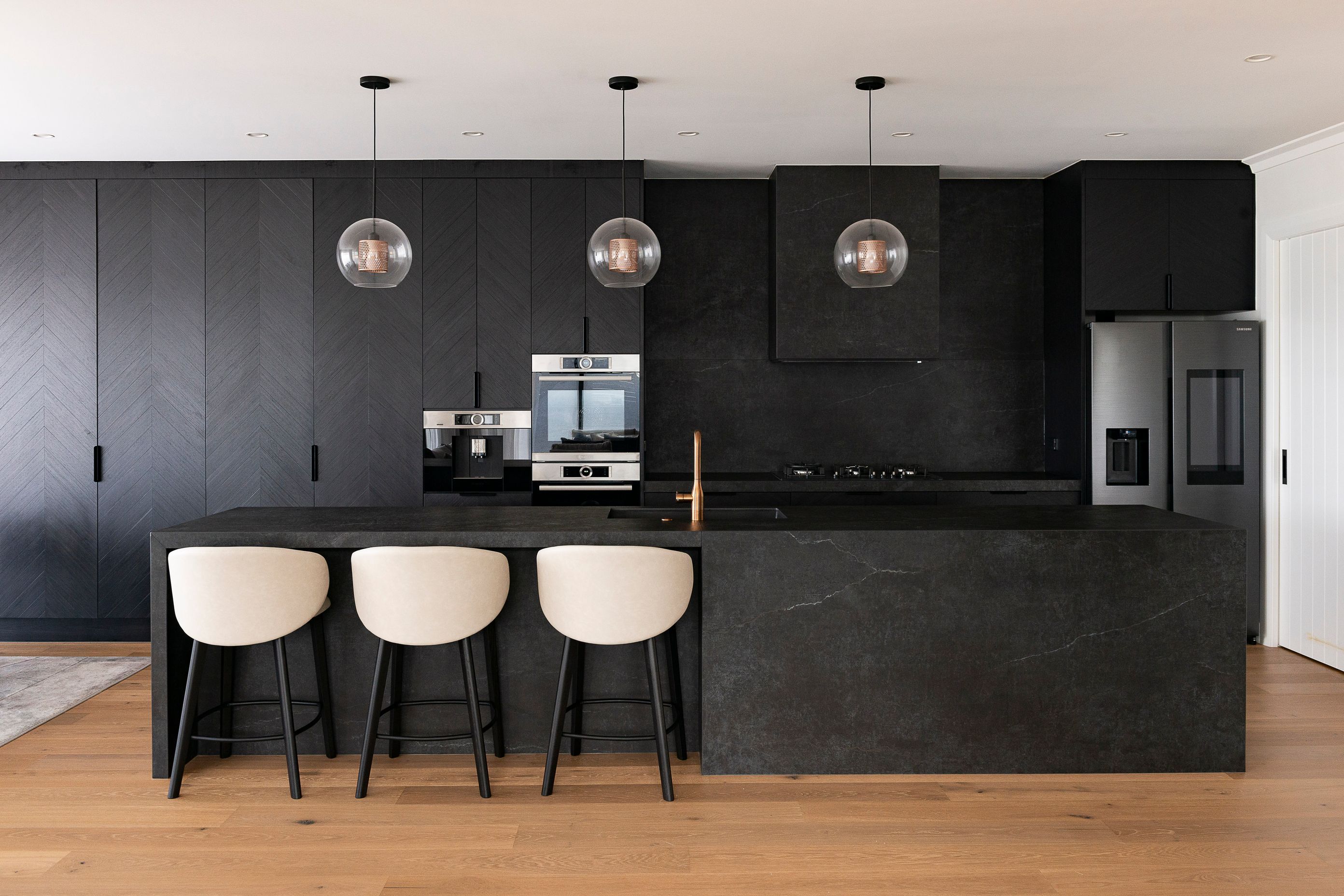 The open-plan kitchen features Dekton Laos on the worktop, splashback, and island.