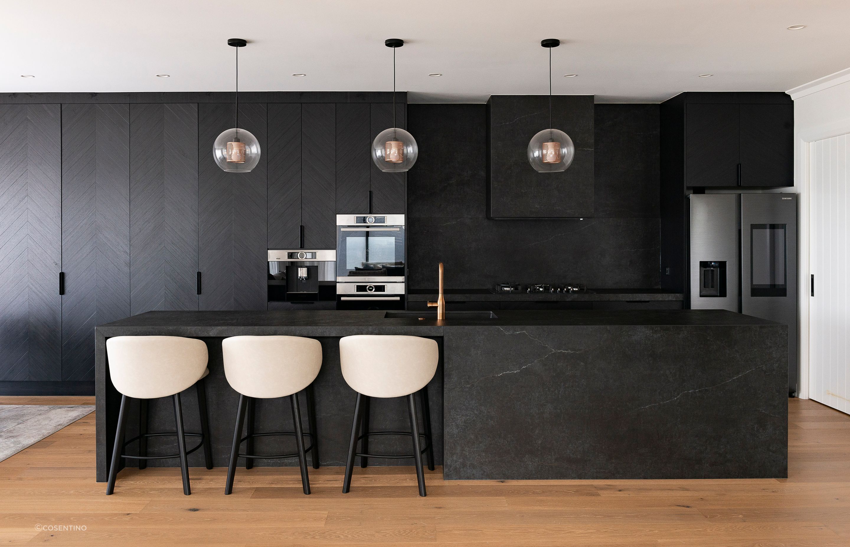 The open-plan kitchen features Dekton Laos on the worktop, splashback, and island.